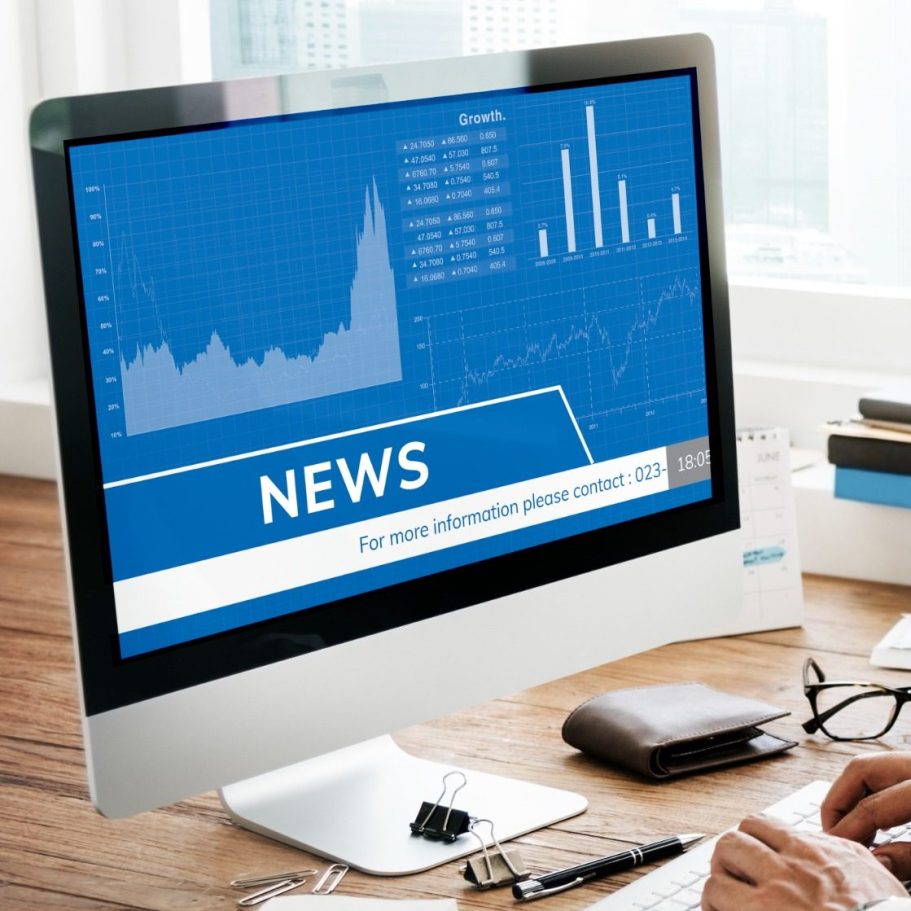Computerbildschirm mit blauer Finanzgrafik und Balkendiagrammen, unten eingeblendet ‚News‘.